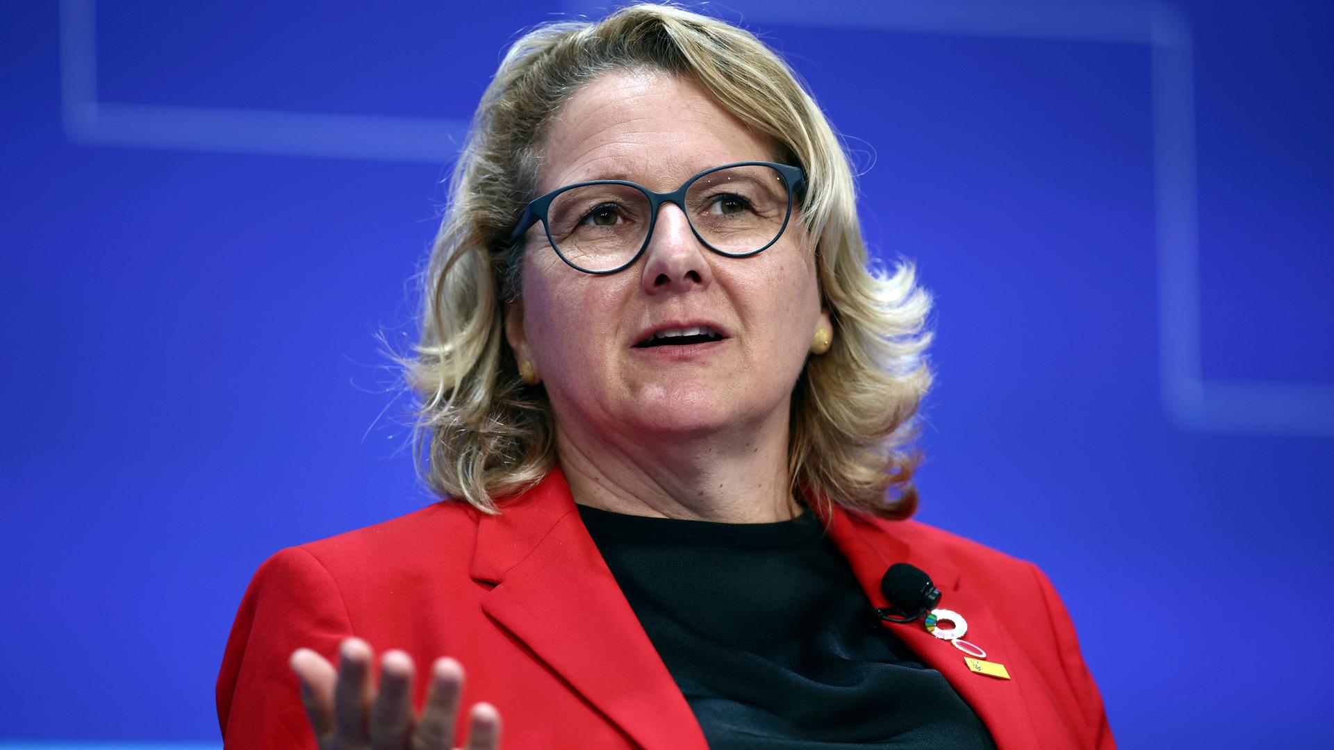 Entwicklungsministerin Svenja Schulze mit Brille im roten Blazer vor blauem Hintergrund. Entwicklungsministerin Svenja Schulze mit Brille im roten Blazer vor blauem Hintergrund.