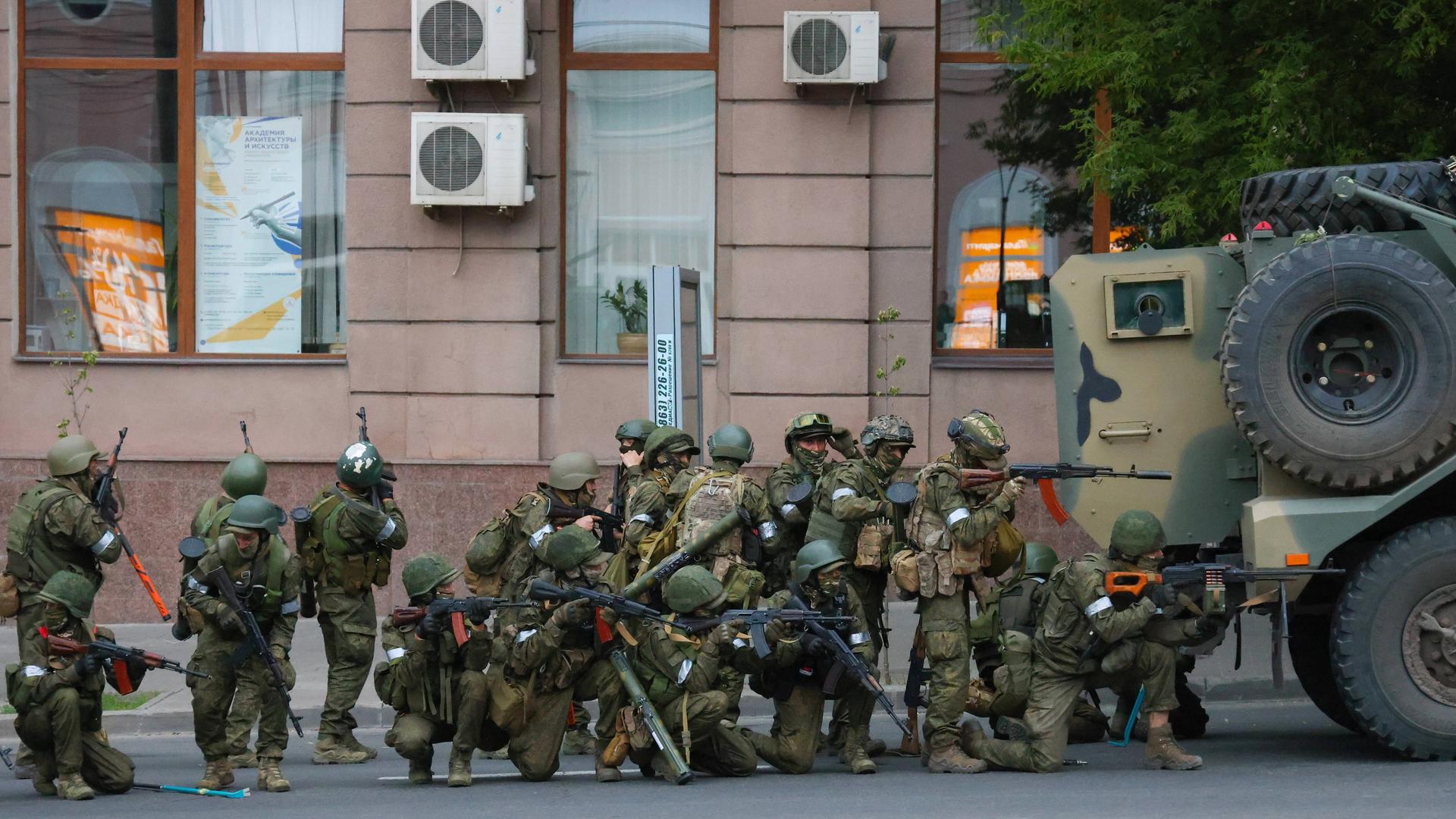 Russland: Wagner-Kämpfer stehen hinter einem Militärfahrzeug vor dem Gebäude des Südlichen Militärbezirks in Rostow am Don. Russland: Wagner-Kämpfer stehen hinter einem Militärfahrzeug vor dem Gebäude des Südlichen Militärbezirks in Rostow am Don.