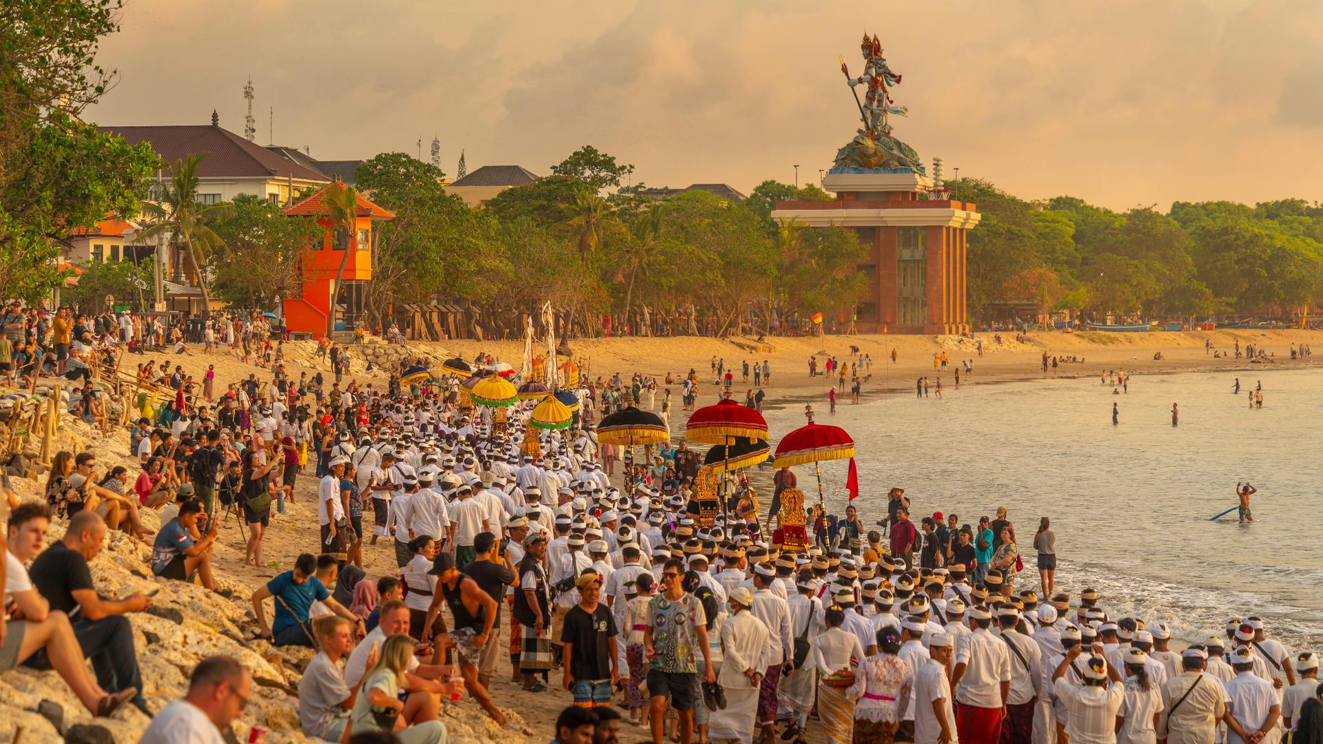 Blick auf den Strand von Kuta. Sowohl Touristen als auch Balinesen sind in traditioneller Kleidung zu sehen Blick auf den Strand von Kuta. Sowohl Touristen als auch Balinesen sind in traditioneller Kleidung zu sehen