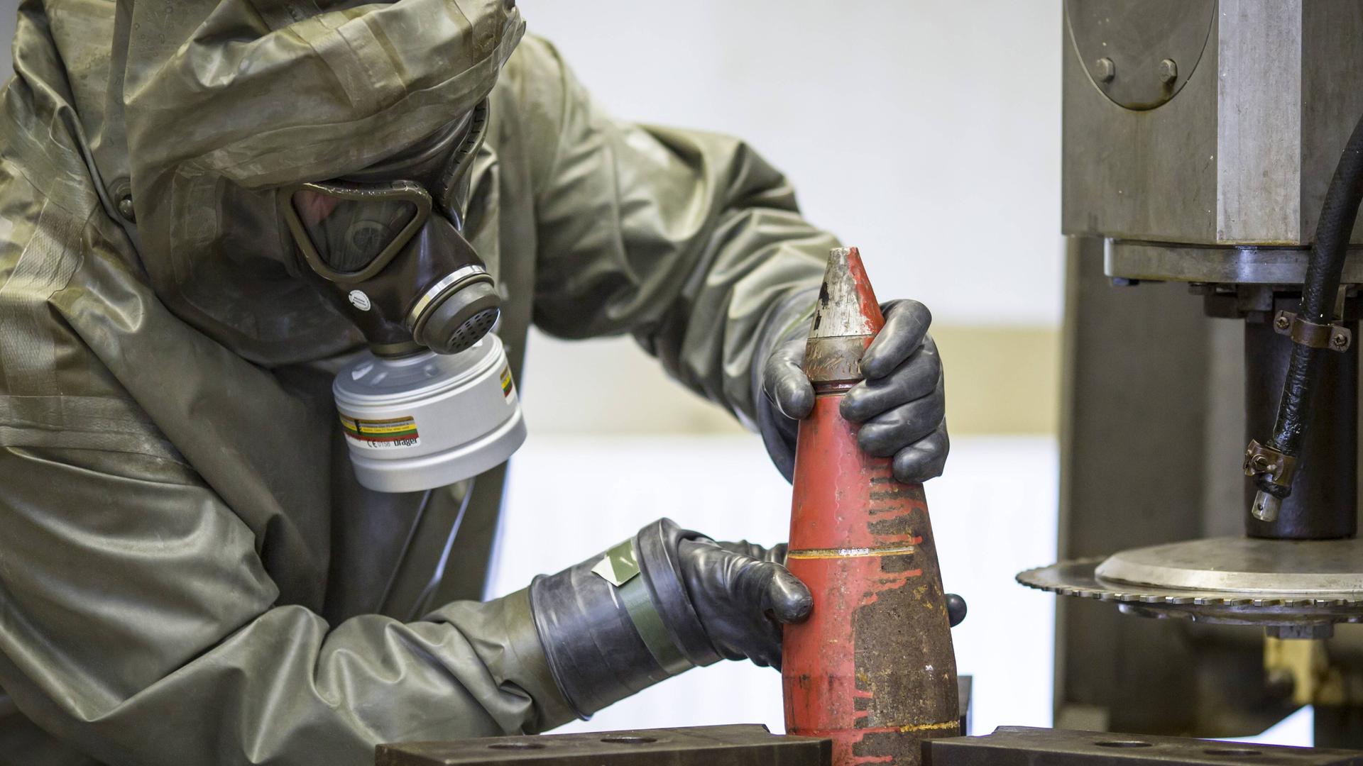 Mitarbeiter des Unternehmens zur Entsorgung chemischer Kampfstoffe und Rüstungsgüter, GEKA, bereiten eine Chemiewaffengranate für die Demontage vor – Trennung von Sprengstoff und Kampfstoff. Mitarbeiter des Unternehmens zur Entsorgung chemischer Kampfstoffe und Rüstungsgüter, GEKA, bereiten eine Chemiewaffengranate für die Demontage vor – Trennung von Sprengstoff und Kampfstoff.