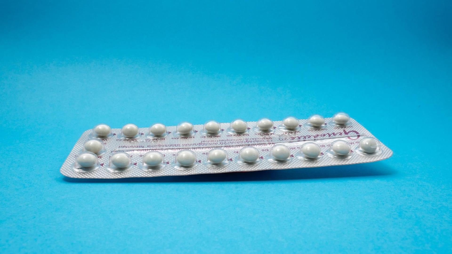 Eine Packung Antibabypillen vor blauem Hintergrund. Eine Packung Antibabypillen vor blauem Hintergrund.