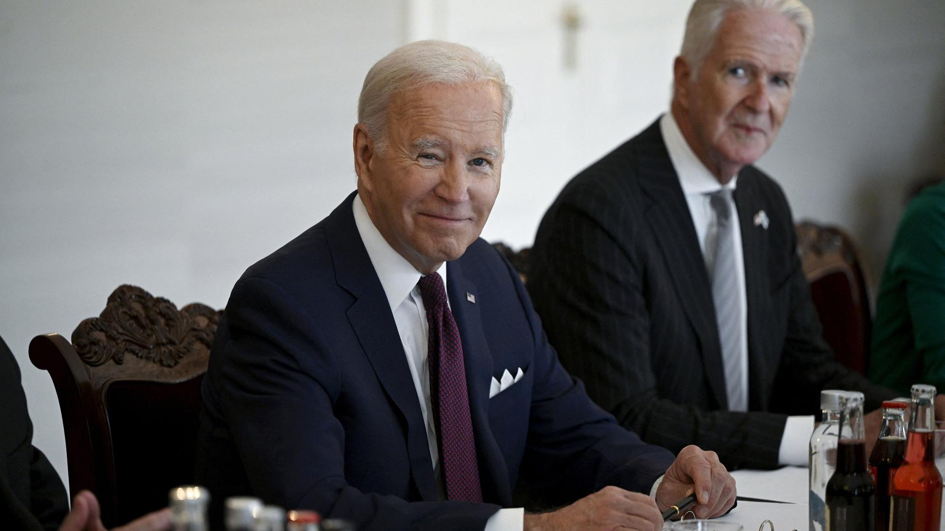 US-Präsident Biden besucht den finnischen Präsidenten Niinistö. Die beiden Politiker sitzen lächelnd an einem Tisch. US-Präsident Biden besucht den finnischen Präsidenten Niinistö. Die beiden Politiker sitzen lächelnd an einem Tisch.