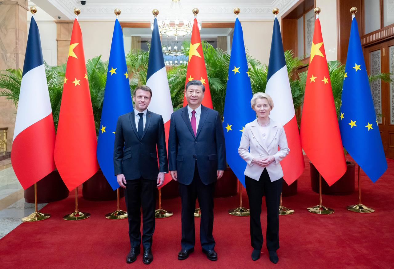 Drei Menschen stehen vor der französischen, chinesischen und europäischen Flagge. Drei Menschen stehen vor der französischen, chinesischen und europäischen Flagge.