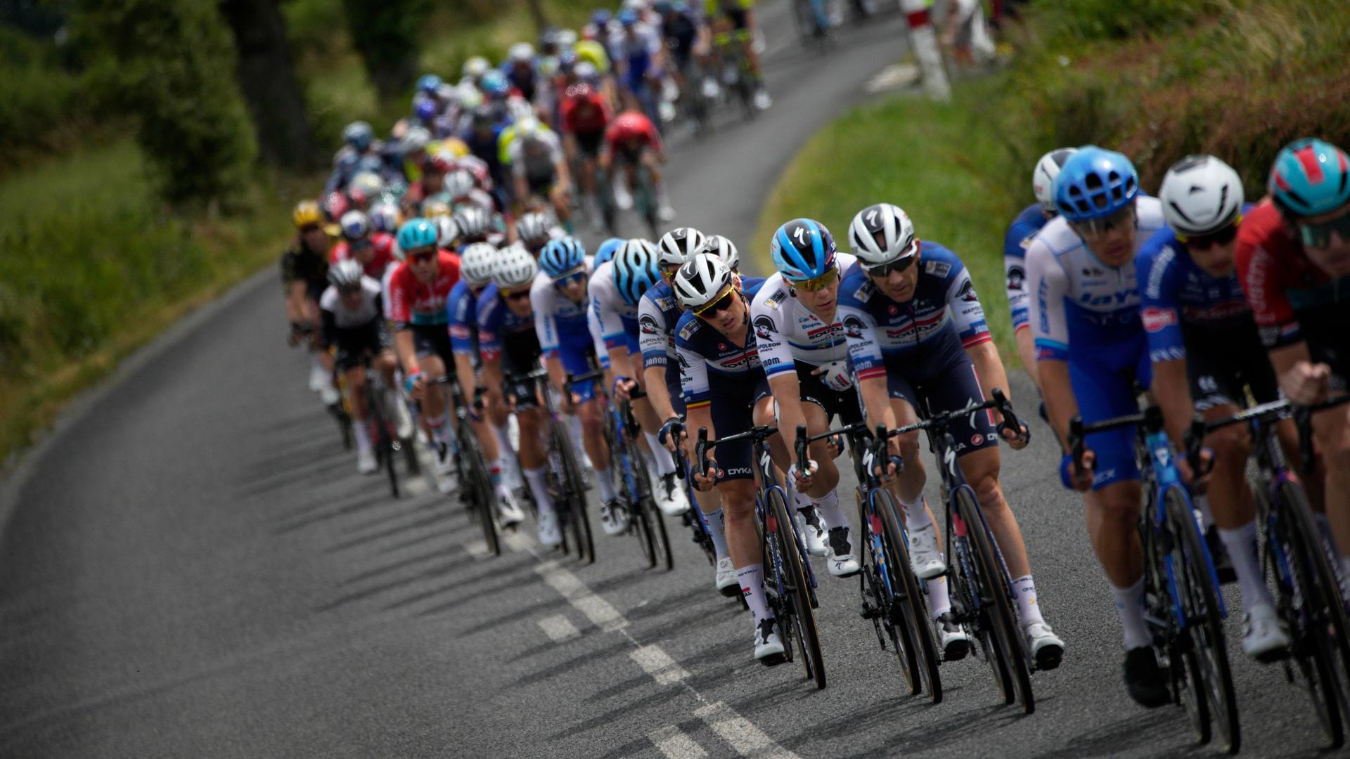 Das Peloton fährt eine grün gesäumte Straße entlang, Schnappschuss von der 11. Etappe der Tour de France am 12.07.2023 Das Peloton fährt eine grün gesäumte Straße entlang, Schnappschuss von der 11. Etappe der Tour de France am 12.07.2023