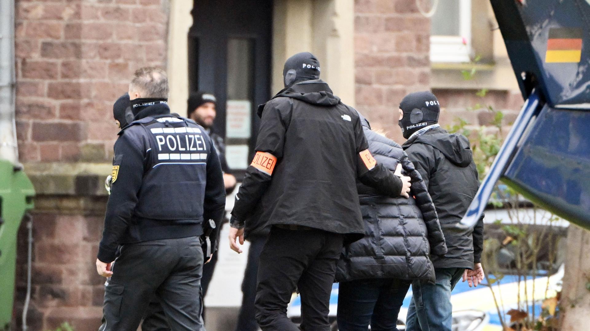 Eine Person (2.v.r.) wird von Polizisten aus einem Hubschrauber gebracht. Die Bundesanwaltschaft hat am Mittwochmorgen mehrere Menschen aus der sogenannten "Reichsbürgerszene" im Zuge einer Razzia festnehmen lassen.
