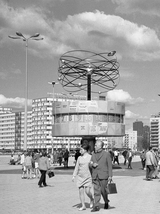 Historische Schwarzweiß-Aufnahme vom Alexanderplatz mit der Weltzeituhr kurz nach der Aufstellung 1969. Die Uhrenanlage mit einer symbolischen Weltdarstellung im Berliner Ortsteil Mitte enthält auf ihrer metallenen Rotunde die Namen von 148 Städten. 