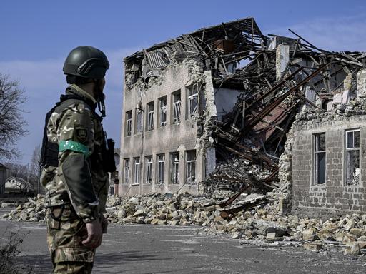 Ein ukrainischer Soldat blickt auf ein zerstörtes Gebäude in der ukrainischen Stadt Toretsk. 