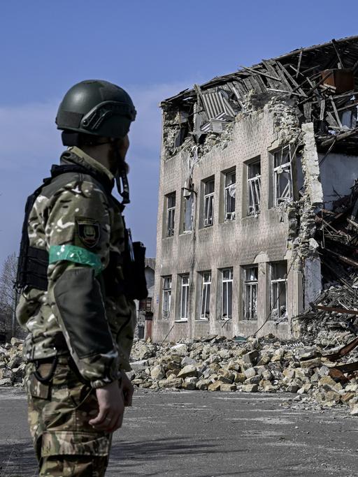 Ein ukrainischer Soldat blickt auf ein zerstörtes Gebäude in der ukrainischen Stadt Toretsk. 