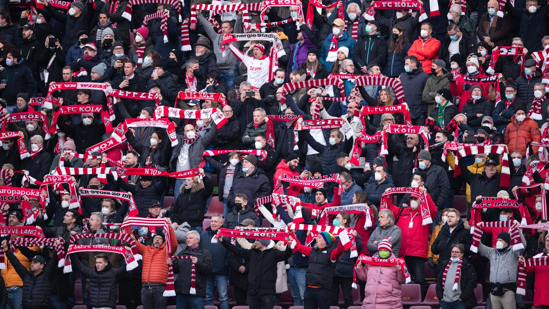 Viele Fußballfans halten ihre Fan-Schals in die Luft Viele Fußballfans halten ihre Fan-Schals in die Luft