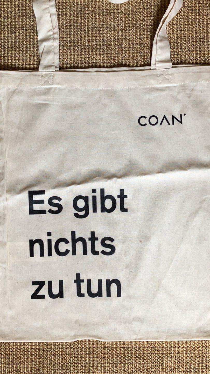 Ein Jutebeutel der Unternehmensberatung Coan, mit der Aufschrift: "Es gibt nichts zu tun". Ein Jutebeutel der Unternehmensberatung Coan, mit der Aufschrift: "Es gibt nichts zu tun".
