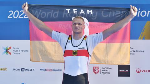 Oliver Zeidler aus Deutschland hält nach seinem Sieg bei der Ruder-WM in Tschechien eine deutsche Fahne hoch.