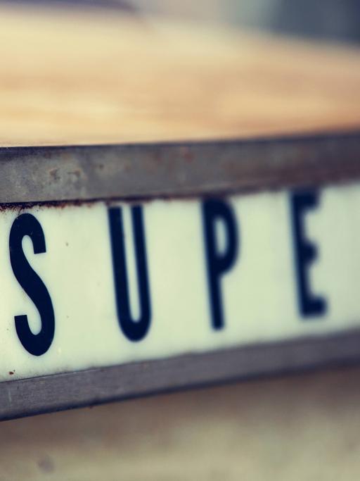 Der Schriftzug "Super" steht in einer alten Zapfsäule.