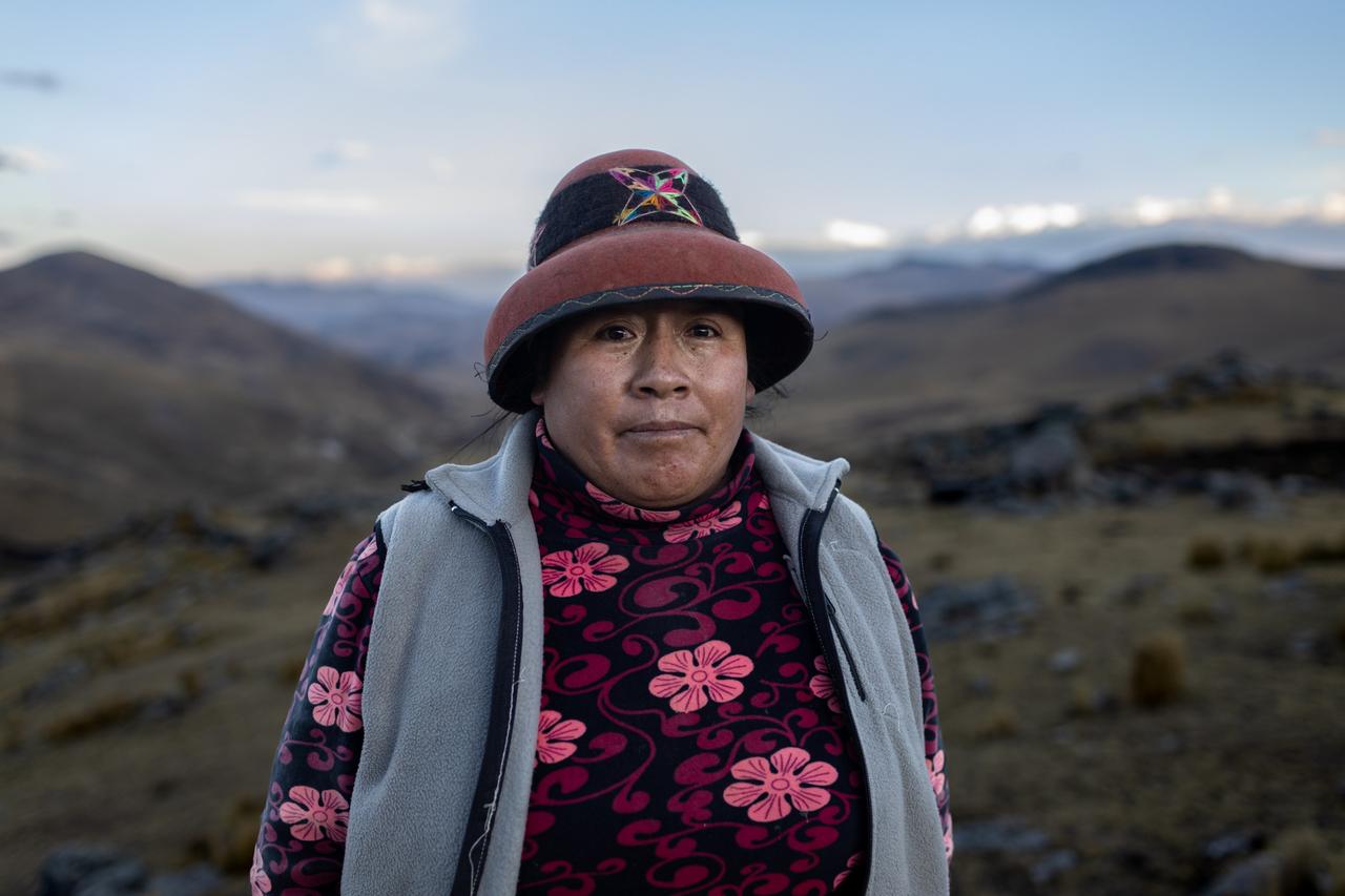 Marcusa Huamani steht im Andenhochland von Peru und trägt traditionelle Kleidung ihrer indigenen Gemeinde mit Blumenmuster und einen Hut. Marcusa Huamani steht im Andenhochland von Peru und trägt traditionelle Kleidung ihrer indigenen Gemeinde mit Blumenmuster und einen Hut.