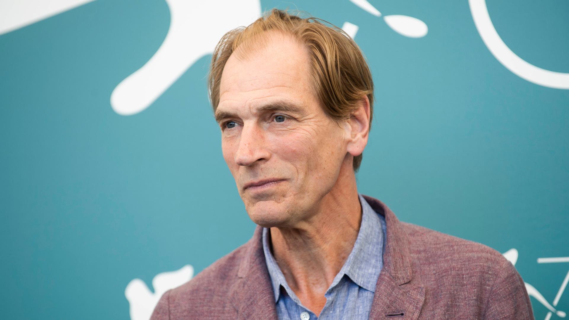 Julian Sands im Jahr 2019 vor einer blauen Wand.