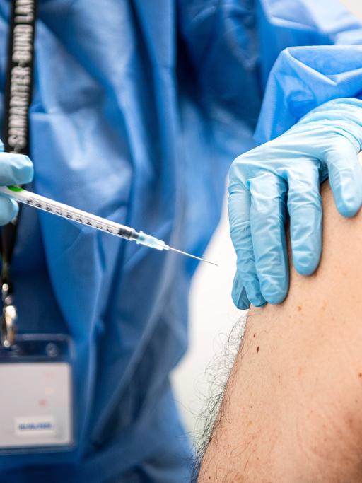 Ein Mann wird in einem Impfzentrum mit dem neuen Spikevax Impfstoff von Moderna geimpft