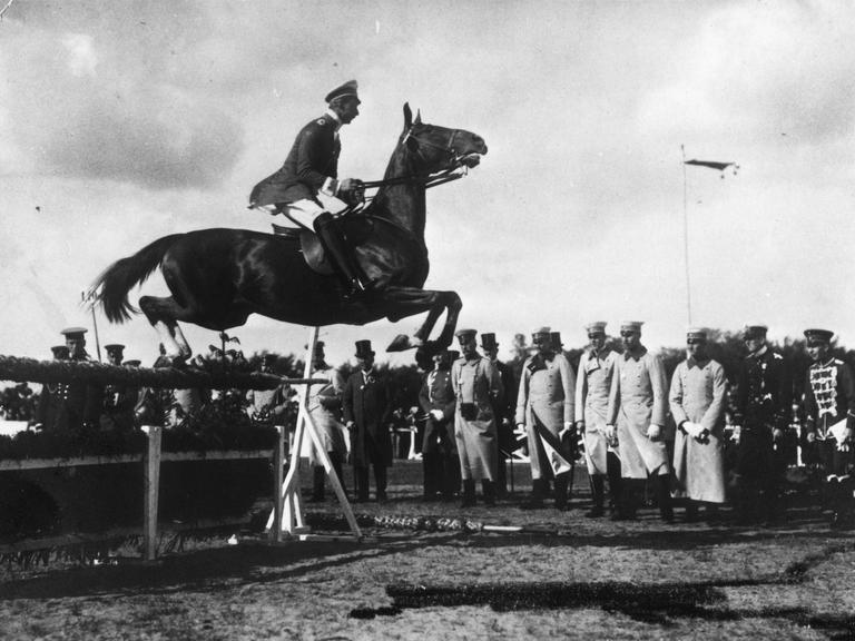 Kronprinz Wilhelm springt auf seiner Fuchsstute beim Concours hippique in Schwerin über ein Hindernis (Foto, um 1910).