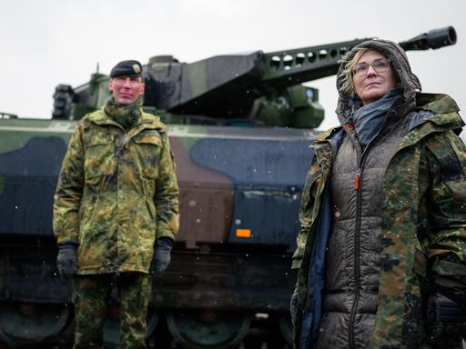 Christine Lambrecht (r, SPD), Verteidigungsministerin, lässt sich bei ihrem Besuch der Panzerlehrbrigade 9 einen Schützenpanzer vom Typ Puma erklären.
