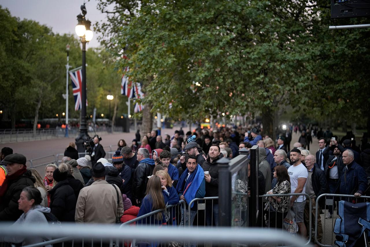 Menschen warten in London auf der Prachtstraße The Mall vor Beginn des Staatsbegräbnis zur Beisetzung von Königin Elizabeth II.
