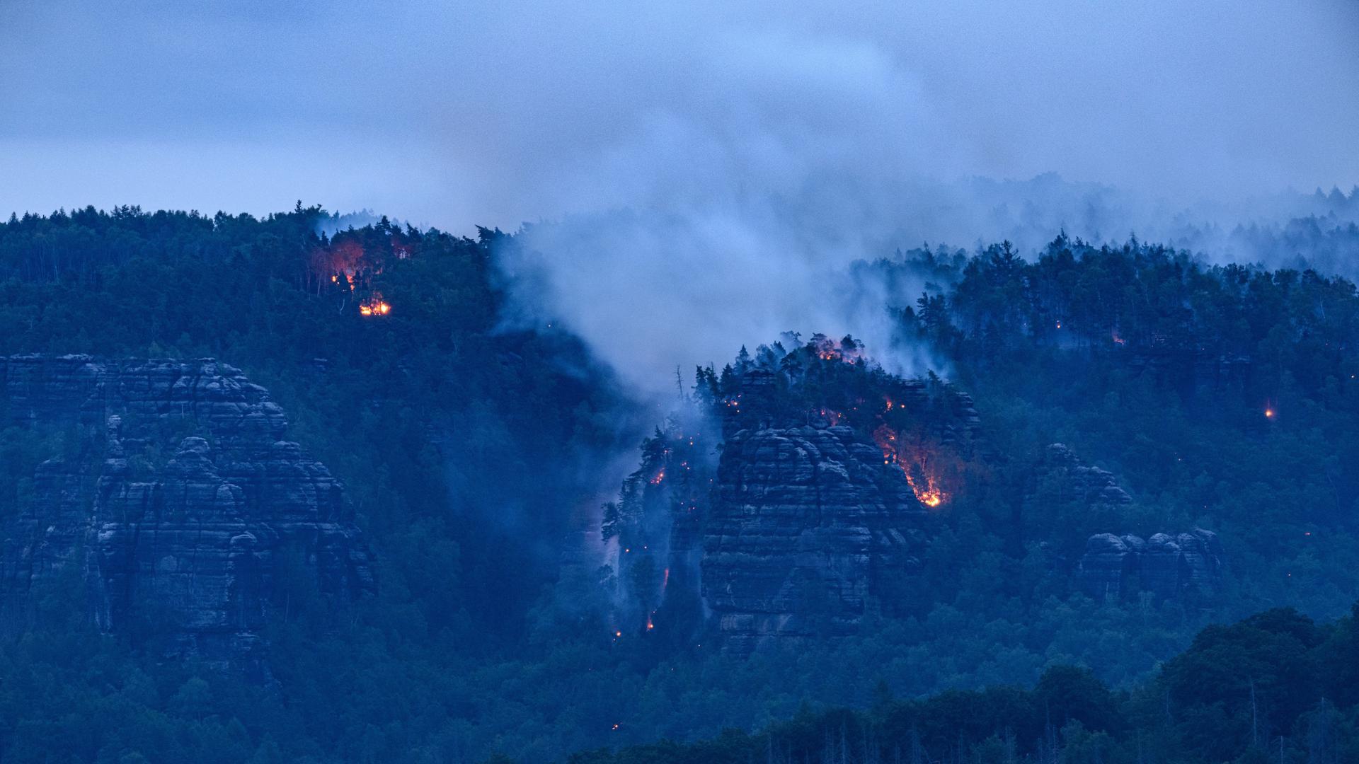 Der Wald brennt im Nationalpark Sächsische Schweiz. In der sächsischen Schweiz erstreckte sich das Feuer am Dienstagabend über 250 Hektar, wie das Landratsamt Sächsische Schweiz-Osterzgebirge mitteilte. 400 Kräfte seien im Einsatz. Weiterhin erschwere insbesondere die Topografie die Löscharbeiten. 27.07.2022 Der Wald brennt im Nationalpark Sächsische Schweiz. In der sächsischen Schweiz erstreckte sich das Feuer am Dienstagabend über 250 Hektar, wie das Landratsamt Sächsische Schweiz-Osterzgebirge mitteilte. 400 Kräfte seien im Einsatz. Weiterhin erschwere insbesondere die Topografie die Löscharbeiten. 27.07.2022