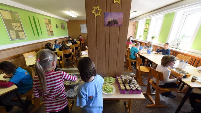 Schüler sitzen beim Mittagessen im Speiseraum einer Grundschule in Thüringen