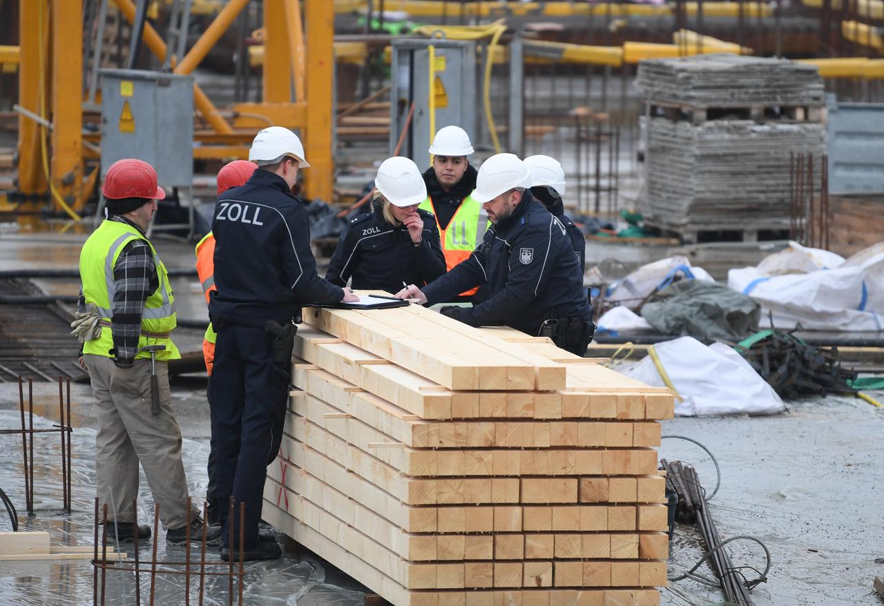 Beamte des Zoll kontrollieren Bauarbeiter während eines Einsatzes auf einer Großbaustelle in Frankfurt am Main