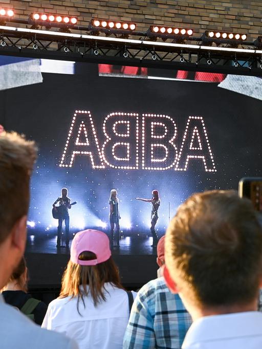 Beim Abba-Event "Abba Voyage" in Berlin standen Fans vor einer großen Leinwand mit Hologramm-Show der Band. 
