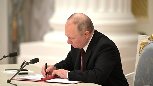 Der russische Präsident Wladimir Putin unterzeichnet am 21. Februar 2022 ein Dokument