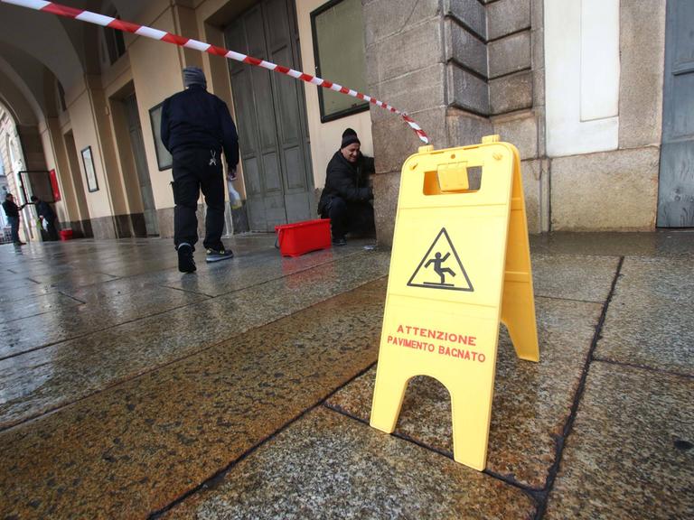 Reinigungskräfte säubern den Eingangsbereich der Scala in Mailand, nachdem Aktivisten der letzten Generation Farbbeutel auf das Gebäude geworfen haben.