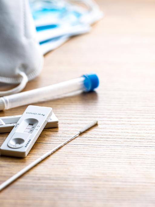 Eine Coronatestkassette mit zwei roten Streifen liegt auf einem Tisch