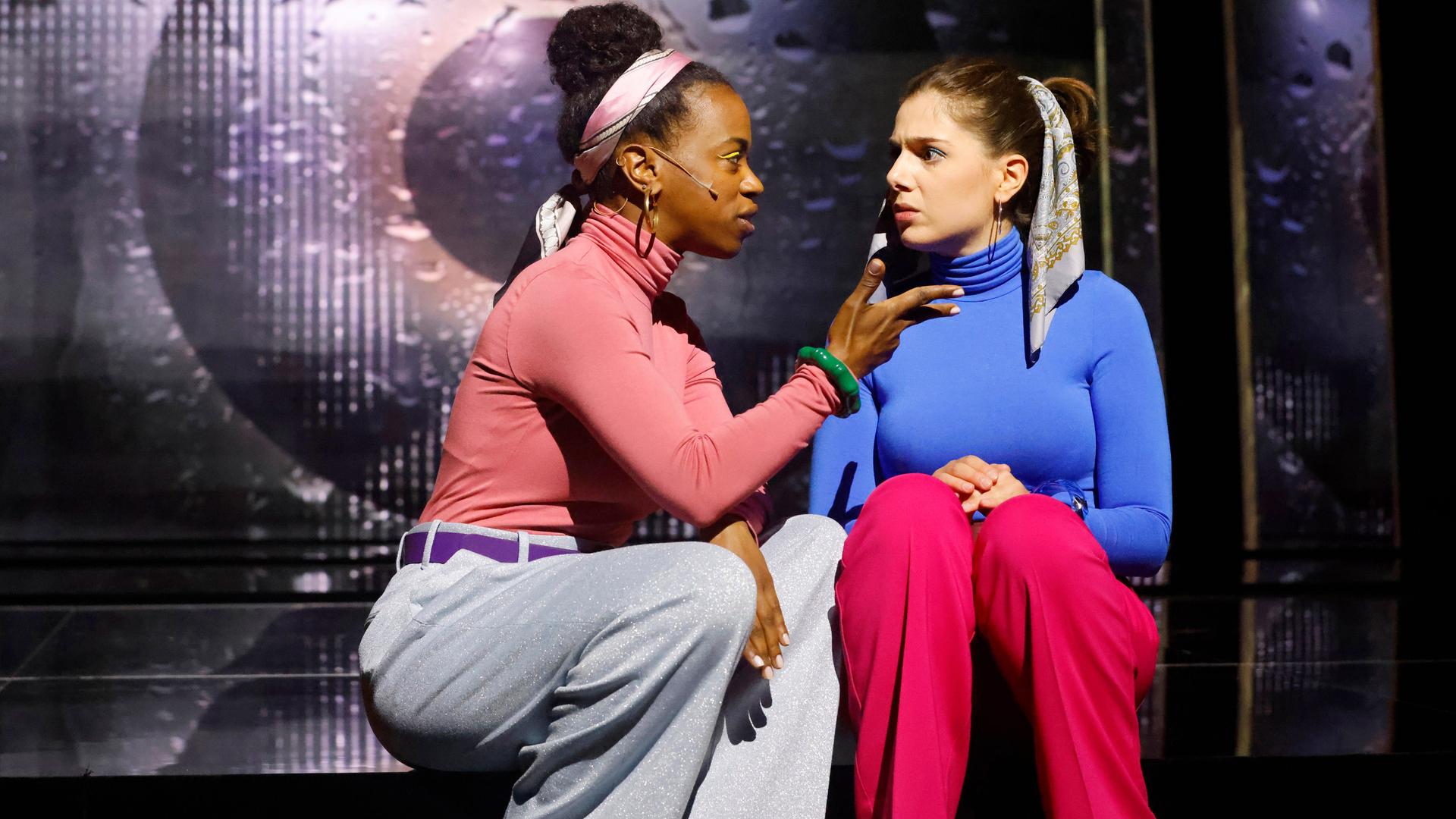 Zwei Frauen sitzen auf der Bühne und unterhalten sich angeregt miteinander.