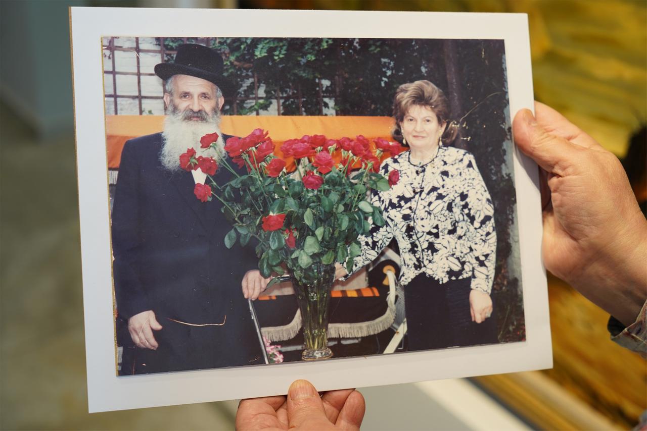 Eine Hand hält ein Foto auf dem Sander Fried und seine Frau Nelly zu sehen sind.