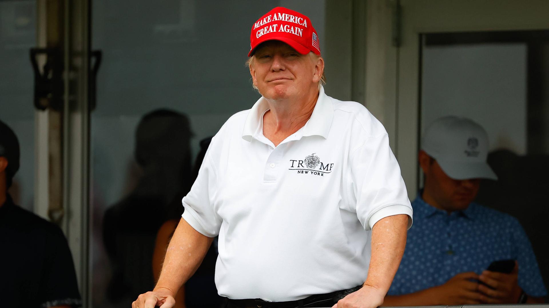Donald Trump lächelt von einem Balkon im Trump National Golf Club in New Jersey. Donald Trump lächelt von einem Balkon im Trump National Golf Club in New Jersey.