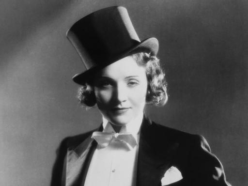 Schwarzweiß-Foto der Schauspielerin Marlene Dietrich  von 1930. Sie trägt Frack und Zylinder.