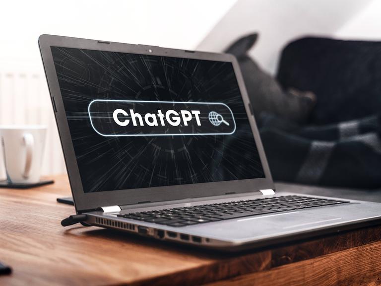 Auf einem Laptop-Bildschirm ist der Schriftzug ChatGPT zu lesen.