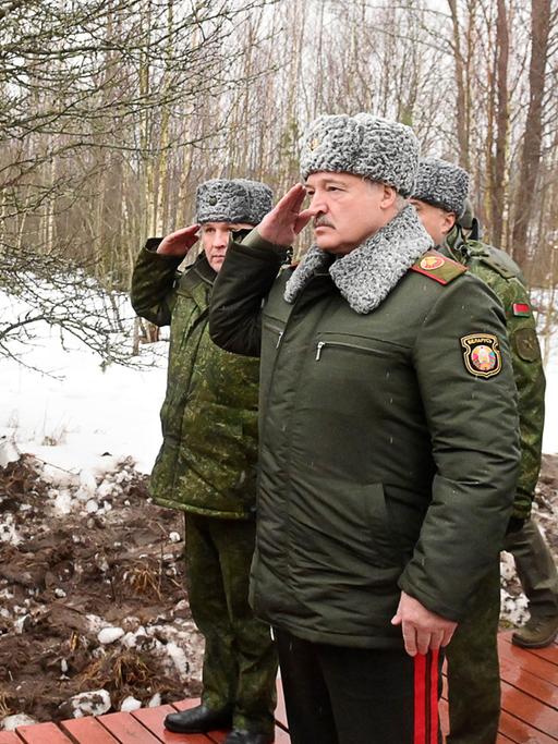 Alexander Lukaschenko in einer Militäruniform grüßt einen Angehörigen der Armee.