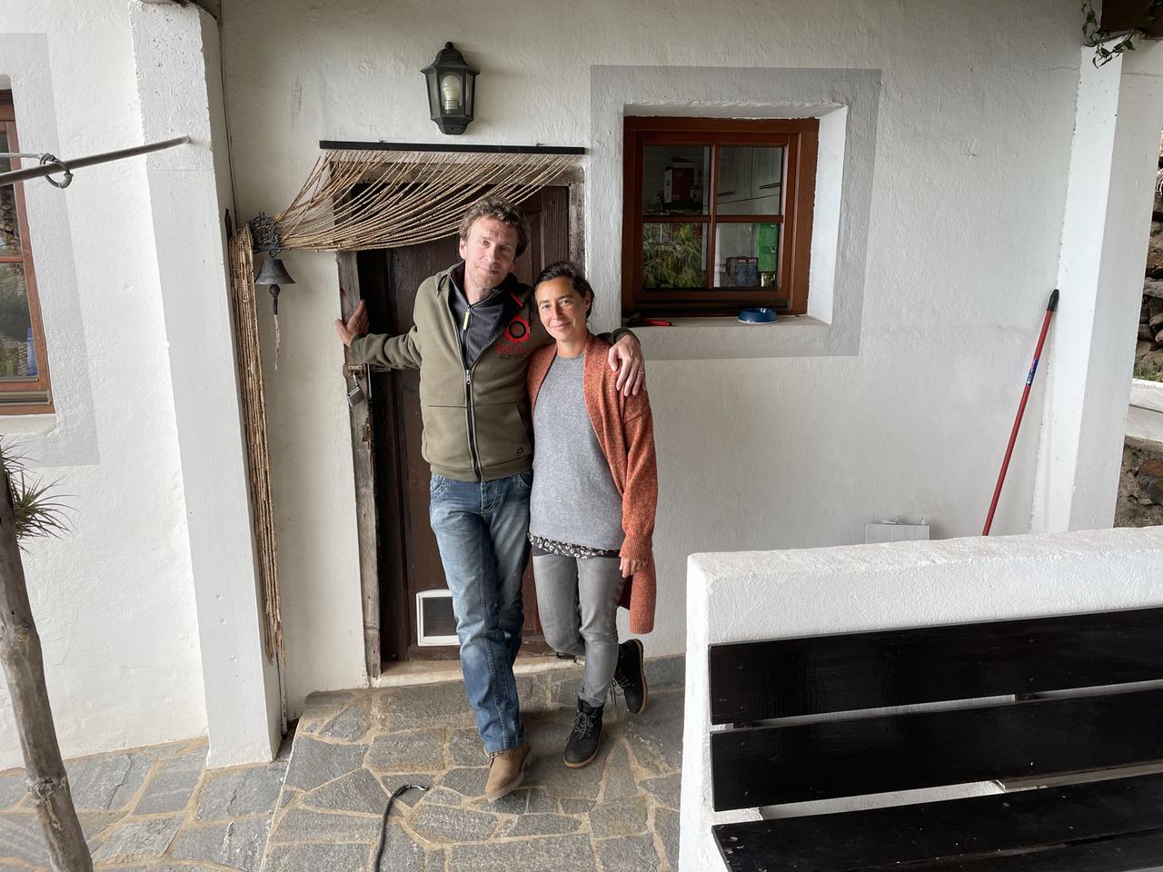 Ein Paar steht an der Tür eines weißen Hauses. Er legt den Arm um sie. Ein Paar steht an der Tür eines weißen Hauses. Er legt den Arm um sie.