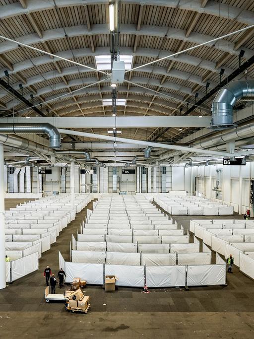 Arbeiter bereiten eine Messehalle in Hamburg für die Unterbringung von Schutzsuchenden aus der Ukraine vor.
