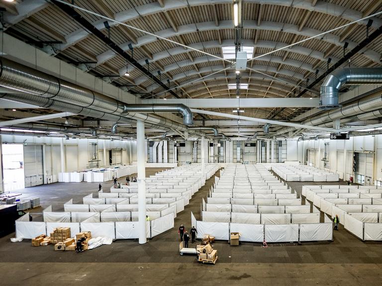 Arbeiter bereiten eine Messehalle in Hamburg für die Unterbringung von Schutzsuchenden aus der Ukraine vor.