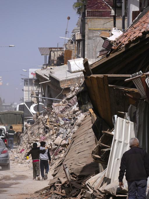 Menschen zwischen zerstörten Häusern in Antakya in der südtürkischen Provinz Hatay