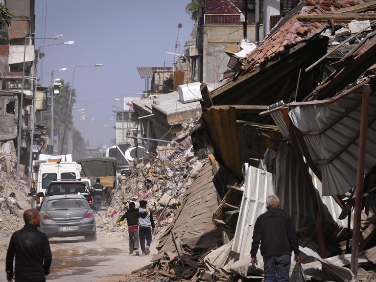 Menschen zwischen zerstörten Häusern in Antakya in der südtürkischen Provinz Hatay