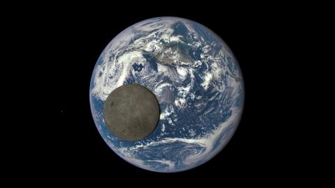 Der Mond vor der Erde aus dem Weltall betrachtet.
