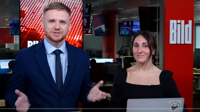 Maksim Kurnikow steht in einem TV-Studio neben einer Frau Maksim Kurnikow steht in einem TV-Studio neben einer Frau
