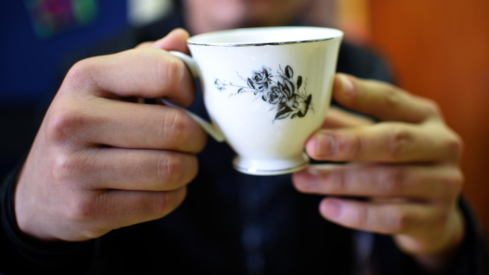 Die Hände eines Mannes aus Afghanistan mit einer Teetasse in den Händen. Die Hände eines Mannes aus Afghanistan mit einer Teetasse in den Händen.