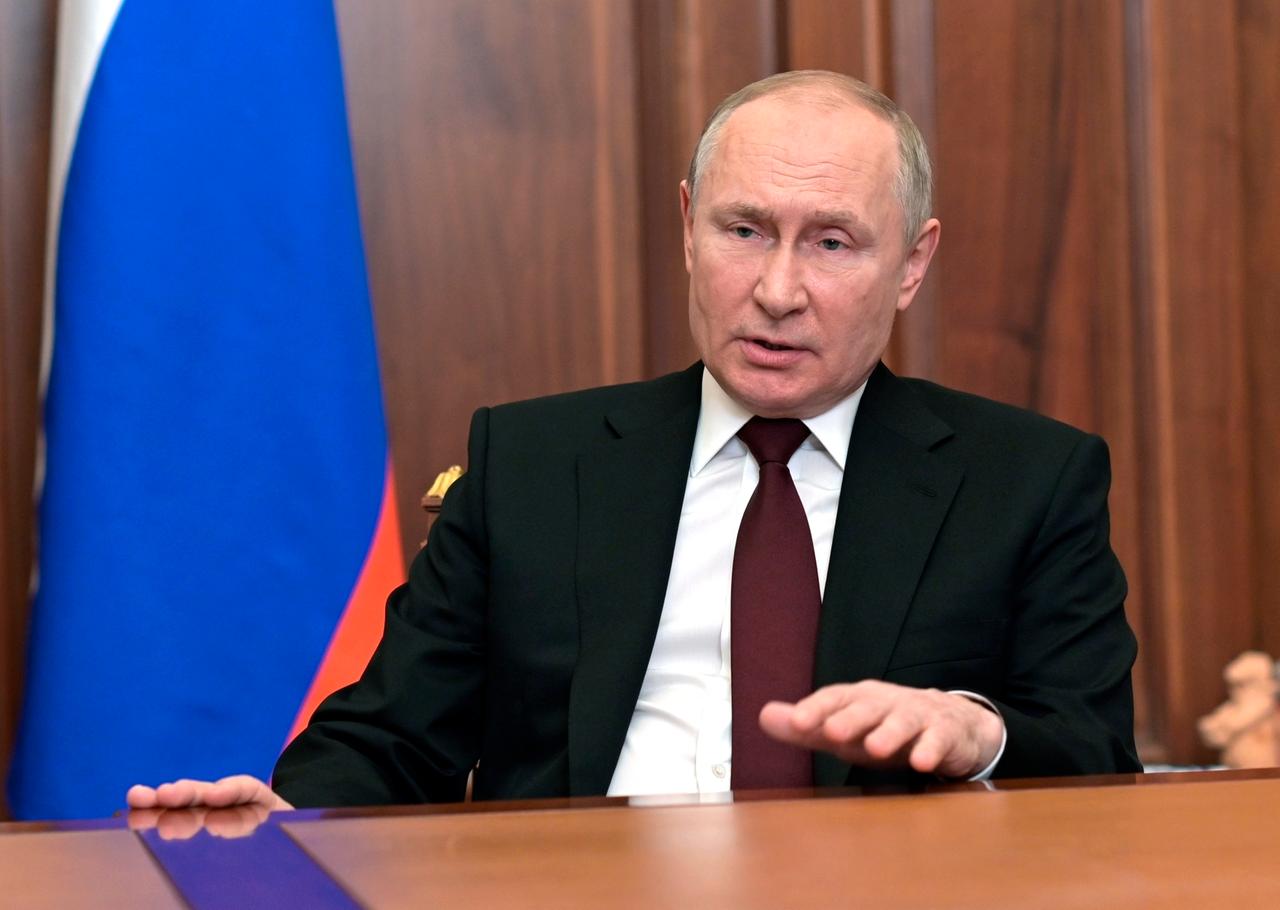Wladimir Putin sitzt an einem Schreibtisch und spricht in die Kamera