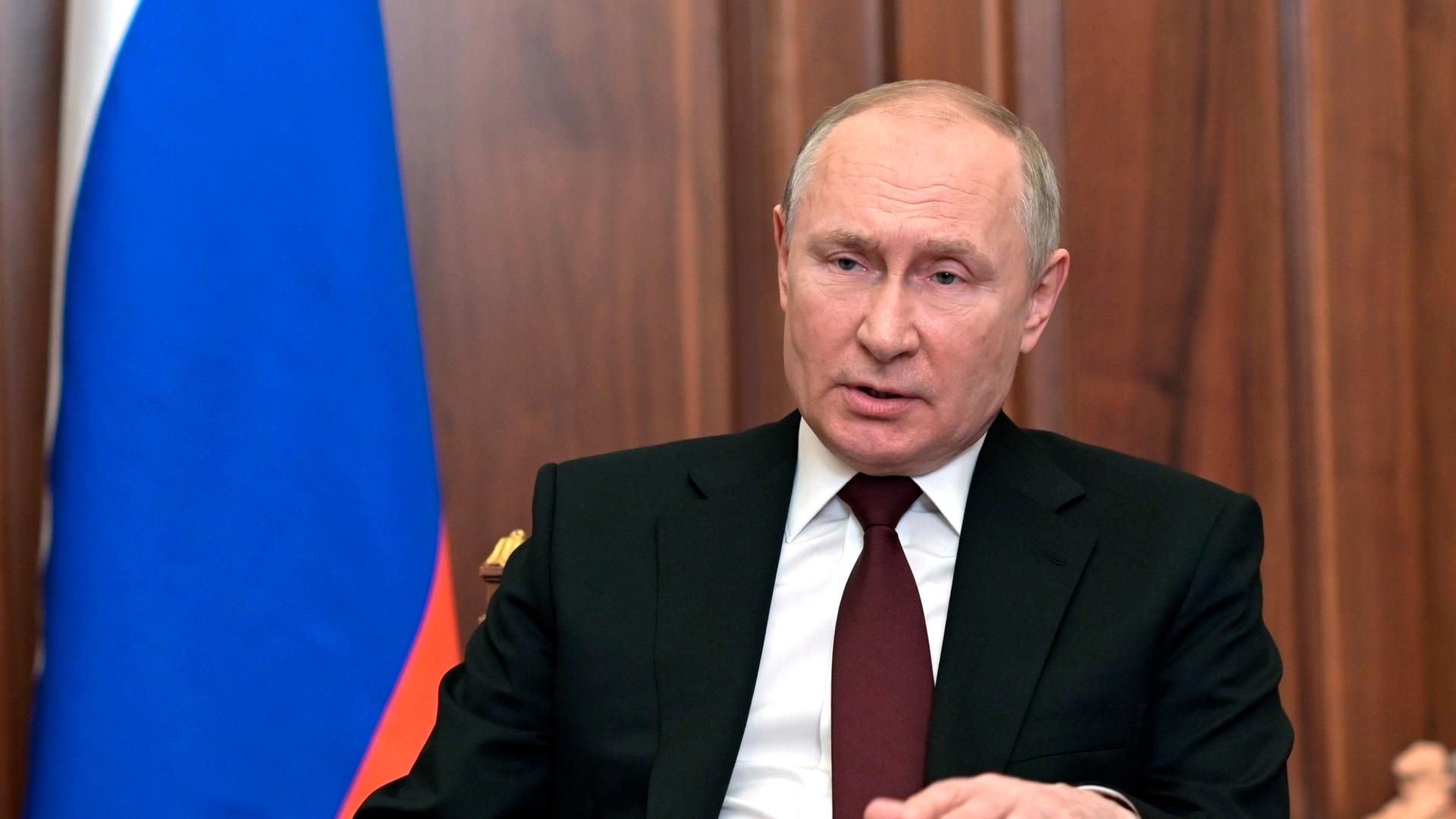 Wladimir Putin sitzt an einem Schreibtisch und spricht in die Kamera Wladimir Putin sitzt an einem Schreibtisch und spricht in die Kamera