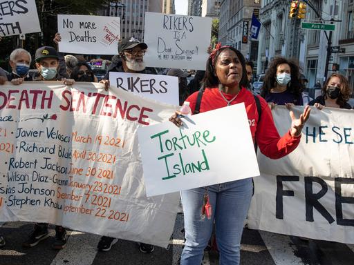 "Torture Island" steht auf einem Schild bei einem Protest in NYC vor der City Hall in Manhattan, weil im Rikers Island Gefängnis Familienangehörige zu Tode kamen.