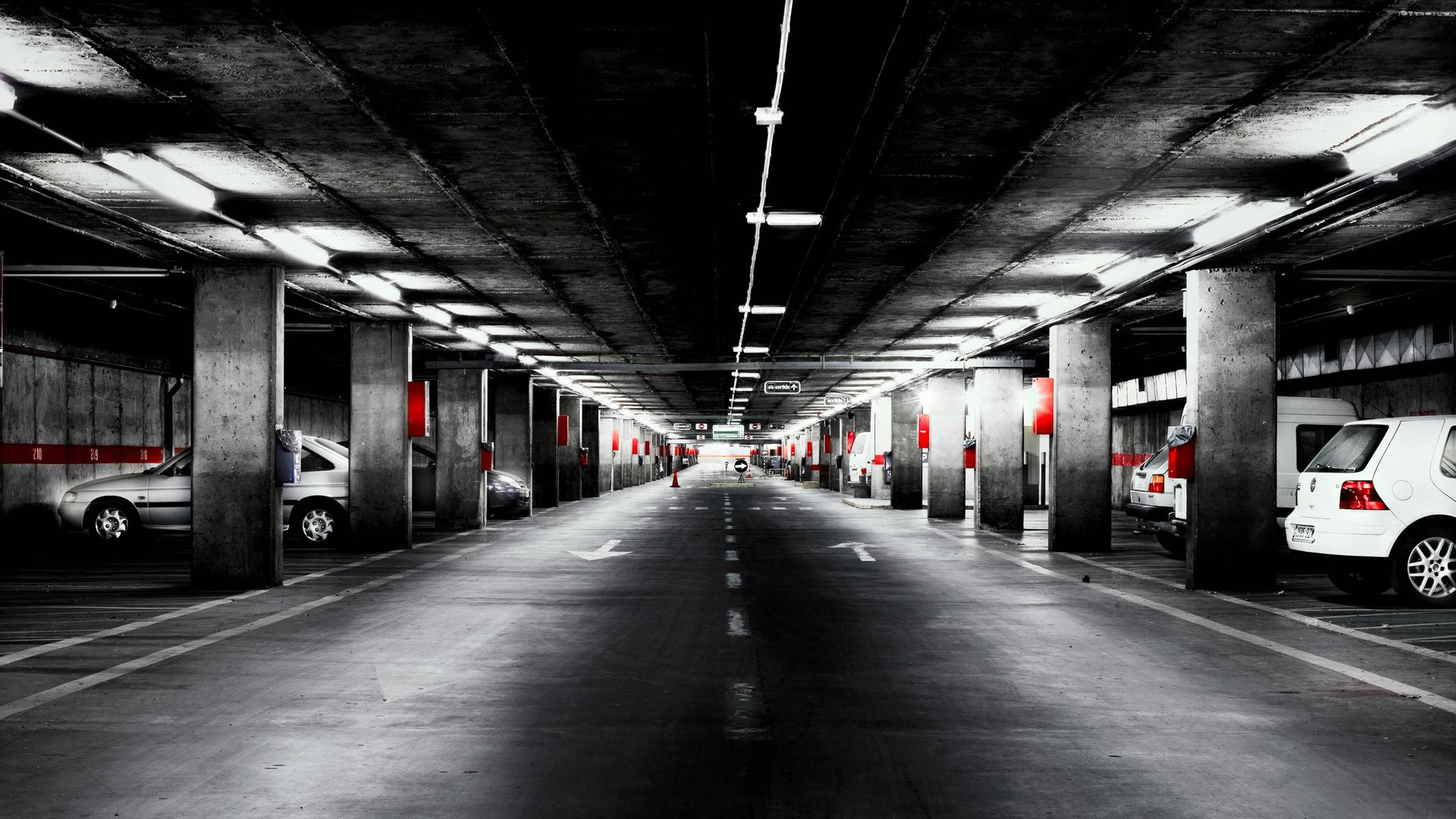 Eine verwinkelte Tiefgarage mit vereinzelten Autos darin. Eine verwinkelte Tiefgarage mit vereinzelten Autos darin.