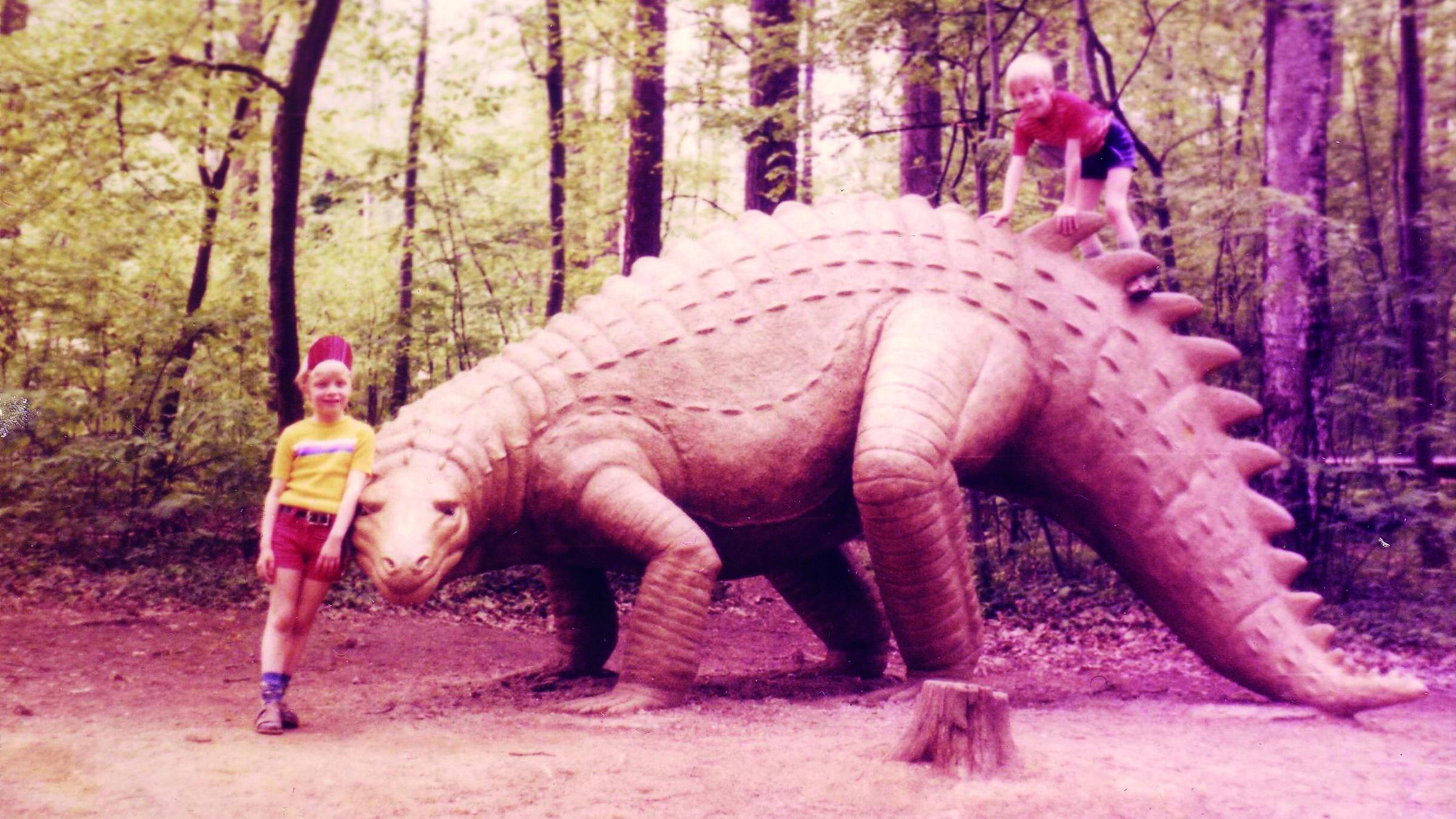 Zwei Kinder posieren neben dem lebensgroßen Modell eines Dinosauriers i...</p>

                        <a href=