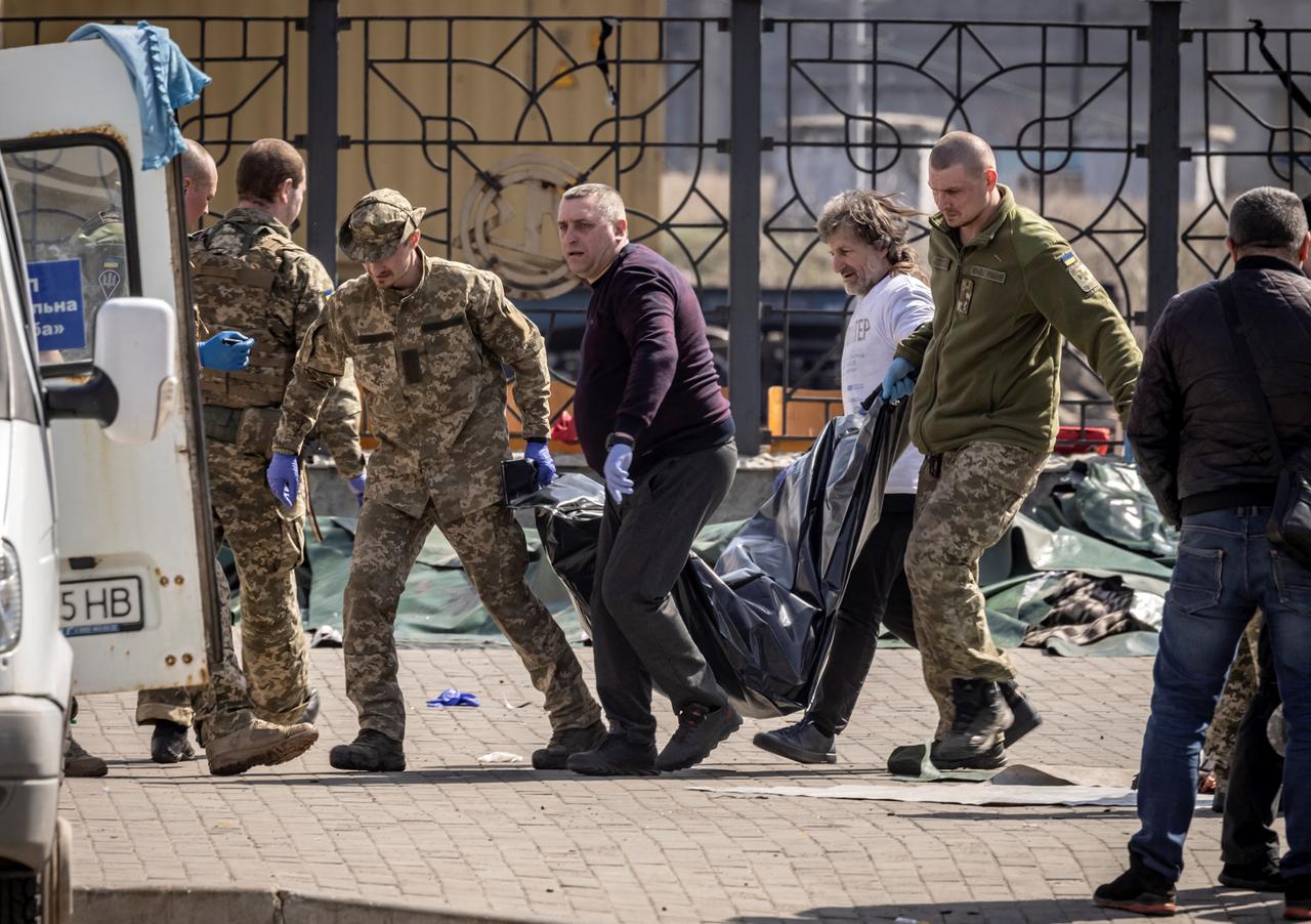 Ukrainische Soldaten und Helfer tragen eine Leiche nach dem Anschlag auf den Bahnhof in Kramatorsk weg.