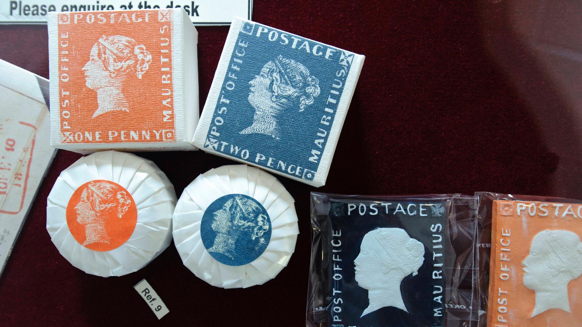 Verschiedene Souvenirs, die das Bild der Briefmarken Blaue und Rote Maritius zeigen, liegen in der Vitrine eines Museums in Port Louis auf der Insel Mauritius.